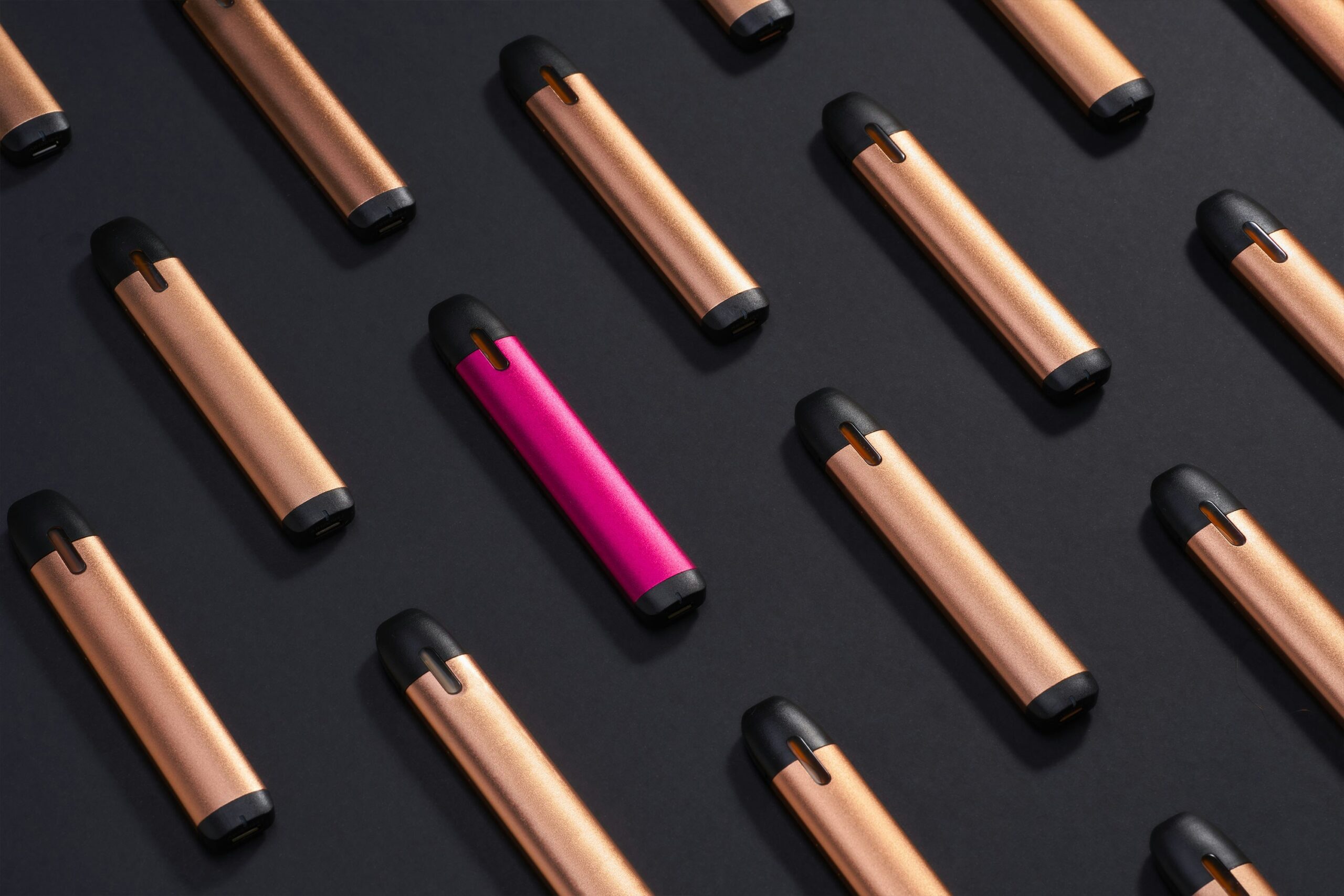 Electronic vaporisers arranged on a dark background